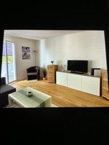a living room with a tv and a couch and a table at Bellavista in Bern