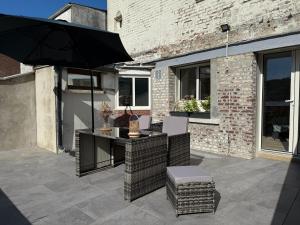 a patio with a table and chairs and an umbrella at Le Nid Marin in Ault
