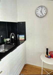 a kitchen with a sink and a clock on the wall at Bellavista in Bern
