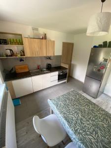 a kitchen with a table and a stainless steel refrigerator at House Hostelli in Grzybowo