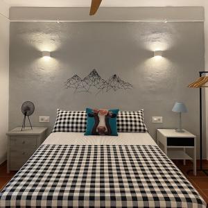 a bedroom with a black and white checkered bed at Casa Rural las Tres Rosas in Gaucín +43 photos