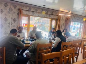 a group of people sitting at a table in a restaurant at HOTEL FOOD POINT & Restaurant in Pahalgām