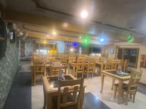 an empty restaurant with wooden tables and chairs at HOTEL FOOD POINT & Restaurant in Pahalgām