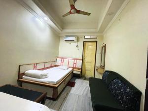 a small room with a bed and a ceiling fan at Hotel Haven in Agartala