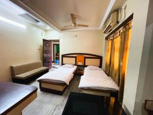 a room with two beds and a couch at Hotel Haven in Agartala