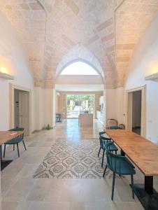 a large room with tables and chairs and an archway at NUX Rooms & Garden in Veglie
