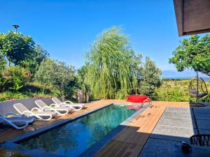 a swimming pool with lounge chairs next to a house at Rezidenca - Villa Cape Of Rodon in Draç