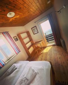 a bedroom with a bed and two windows and a desk at Speiereckhütte in Mauterndorf
