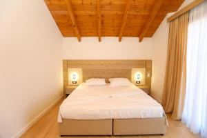 a bedroom with a large bed with white sheets at Guesthouse Micaj LUNI in Himare +15 photos