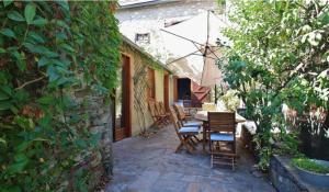 a patio with chairs and a table and an umbrella at La Maison d'Aimée in Vielle-Aure