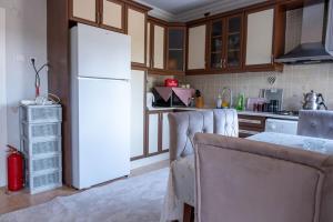 a kitchen with a white refrigerator and some chairs at Golden Tree in Karaağaç