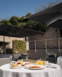 a table with plates of food and drinks on it at Nun Assisi Relais & Spa Museum in Assisi