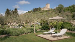 two chairs and an umbrella in a garden at Nun Assisi Relais & Spa Museum in Assisi