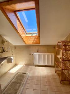 a bathroom with a large skylight and a large tile floor at Ferienwohnungen in Schönmünzach in Baiersbronn +79 photos