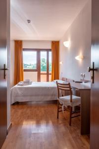 a bedroom with a bed and a desk and a table at Hotel La Carica in Pastrengo