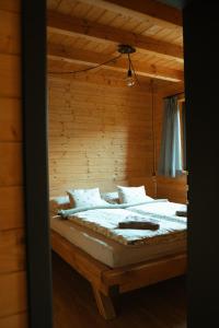 a bedroom with a large bed with a wooden wall at Chata Cedrus in Hradišťko