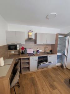 a kitchen with white cabinets and a desk with a sink at Apartments SEEA in Izola