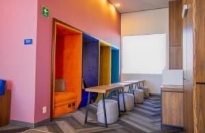 a row of tables in a room with colorful walls at Tru By Hilton Puebla Angelopolis in Puebla