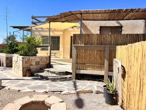 a house with a wooden fence and a building at וילה אושר in Mitzpe Ramon