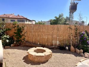 a backyard with a wooden fence and a stone bench at וילה אושר in Mitzpe Ramon +23 photos