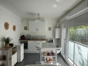 a kitchen with white cabinets and a large window at Studio Leman Ciel avec parking privé gratuit in Gex