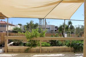a large yellow canopy over a garden with plants at וילה אושר in Mitzpe Ramon