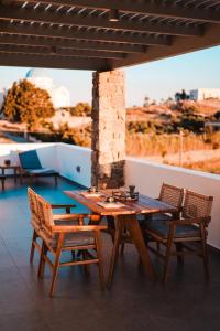 a wooden table and chairs on a patio with a view at Enki's Heaven Premium Apartments in Glinádhon