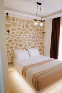 a bed in a room with a stone wall at Enki's Heaven Premium Apartments in Glinádhon +105 photos
