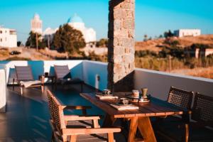 a wooden table and chairs on a balcony at Enki's Heaven Premium Apartments in Glinádhon