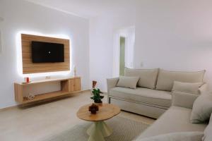 a living room with a couch and a tv at Enki's Heaven Premium Apartments in Glinádhon