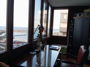 a room with a desk and windows with a view at appartamento in Bisceglie