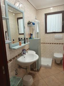 a bathroom with a sink and a toilet and a mirror at appartamento in Bisceglie