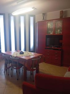 a dining room table with chairs and a television at appartamento in Bisceglie