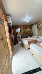 a room with two beds and a tv in it at Pousada Recanto das Fontes in Beberibe
