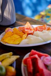 two plates of cheese and fruit on a table at Pousada Templo Aláfia in Vera Cruz de Itaparica