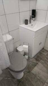 a white bathroom with a toilet and a sink at Kelinda in Les Abymes