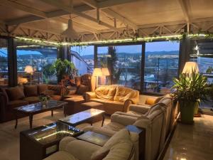 a living room with couches and tables and windows at Horizont 360 Gold in Vrnjačka Banja