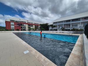 a man standing in the water next to a swimming pool at U Are We R St Martin Studio Cosy Marigot, Wi-Fi ,Piscine in Marigot