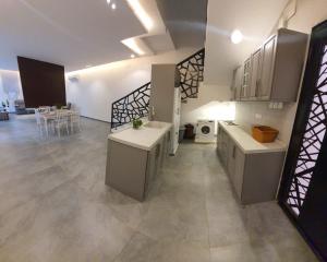a large kitchen with white cabinets and a dining room at فلل و شقق سحاب أبها in Abha