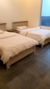 two beds sitting next to each other in a room at فلل و شقق سحاب أبها in Abha
