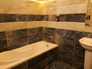 a bathroom with a bath tub and a toilet at Royal Hostgram and Suites in Cairo