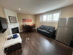 a living room with a couch and a refrigerator and a table at Luxurious Vacation in Welland