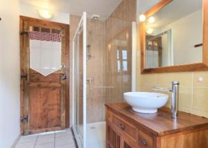 a bathroom with a sink and a shower with a mirror at La Maison d'Aimée in Vielle-Aure
