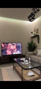 a living room with a large flat screen tv at غرفة وصالة دخول ذكي in Al Fayşalīyah