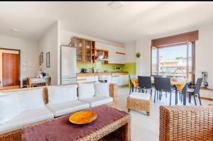 a living room with a white couch and a kitchen at Raggio Di Sole in Cosenza