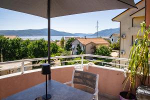 a balcony with a table and an umbrella at Apartments Kuc in Tivat