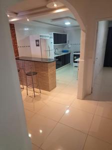 a kitchen with a counter and chairs in a room at espaço inteiro no bairro mais tranquilo de gravatá in Gravatá +4 photos