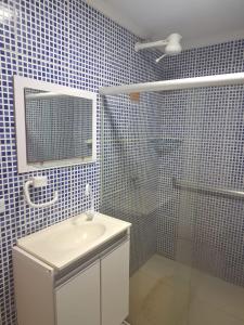 a bathroom with a sink and a shower with a mirror at espaço inteiro no bairro mais tranquilo de gravatá in Gravatá