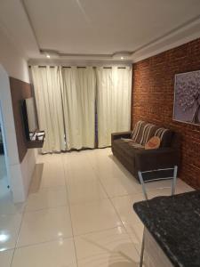 a living room with a couch and a brick wall at espaço inteiro no bairro mais tranquilo de gravatá in Gravatá
