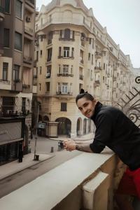 a man standing on a ledge holding a camera at Royal Hostgram and Suites in Cairo